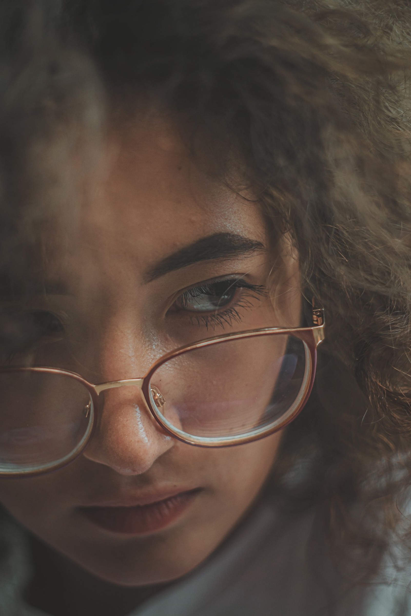 Close portrait showing a woman's face behind eyeglass frames