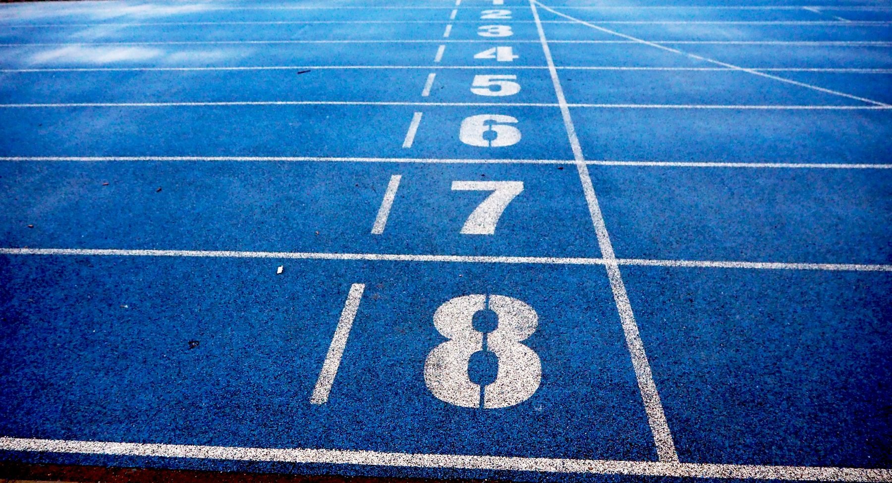 Empty blue running track with numbered lanes