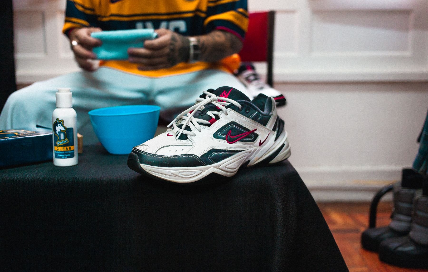 Sneaker and shoe-cleaning supplies arranged on a black table