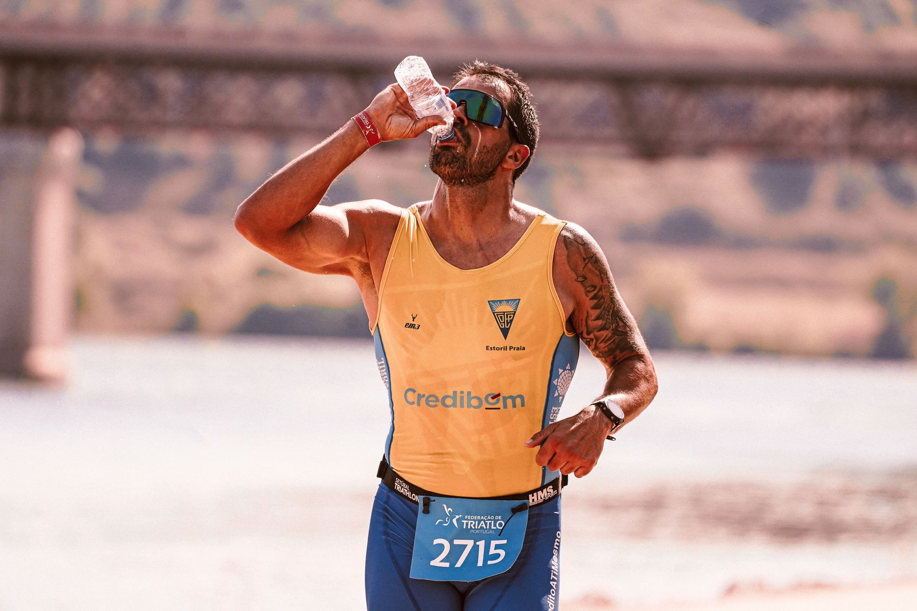Male road-race runner drinking water while moving